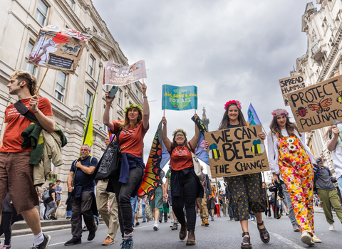 People with placards marching through a city street.